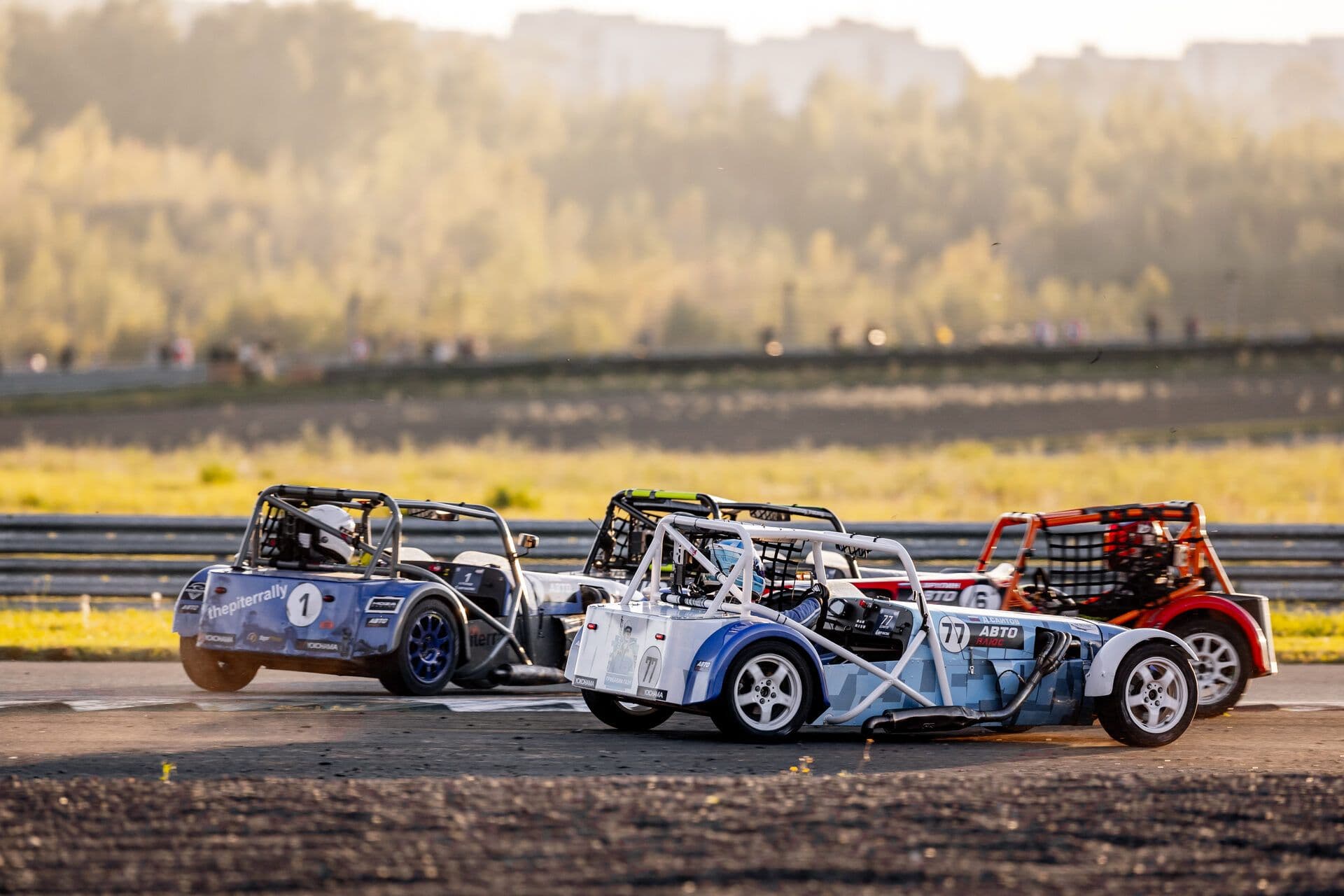 Три гоночных родстера на закате во время квалификации